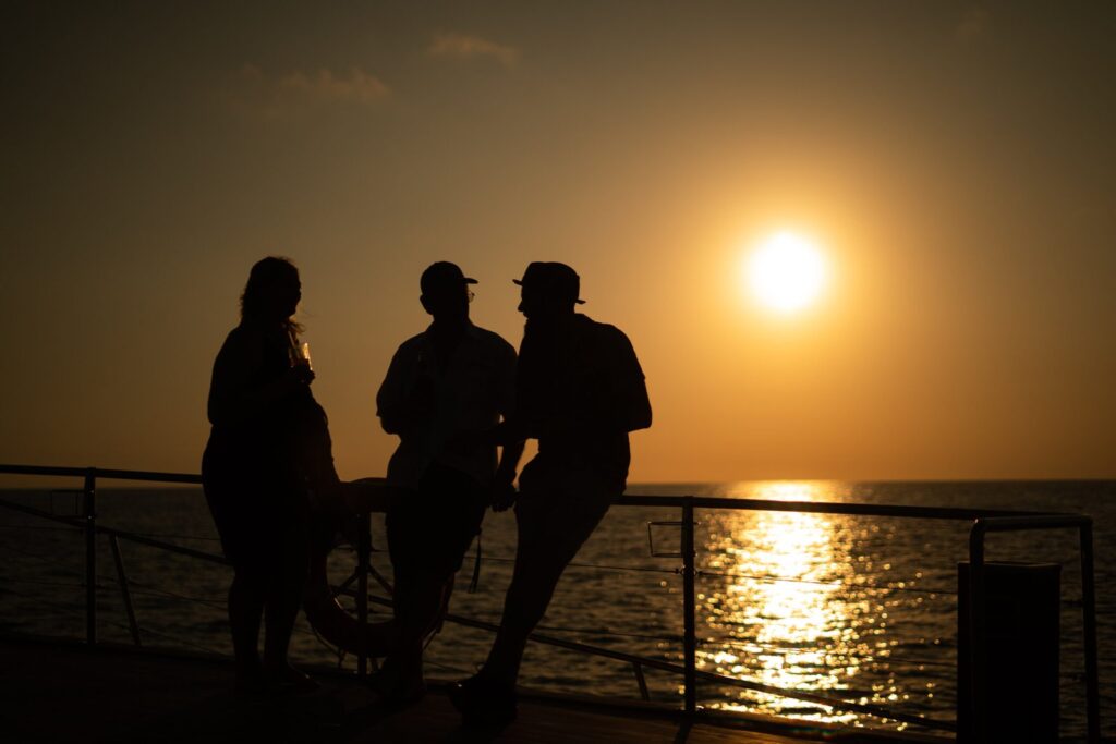 group of people enjoying sunset on a yacht
